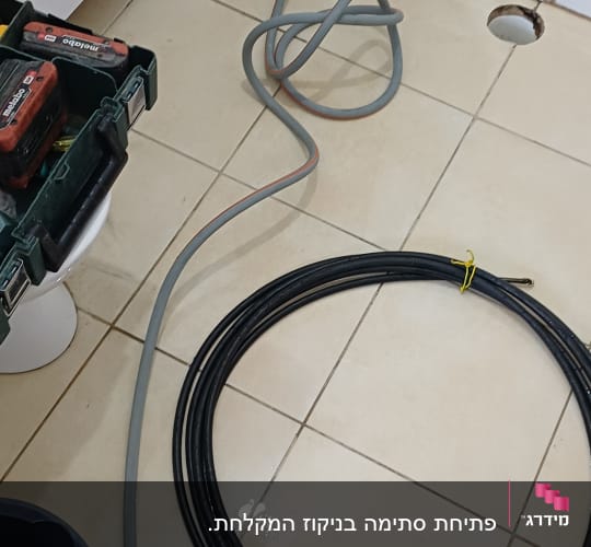 כלים וחוטים בעבודת אינסטלציה בחדר אמבטיה